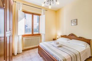 un dormitorio con una cama y una ventana en Homes Boccaccio Beautiful Terrace - Happy Rentals, en Montespertoli