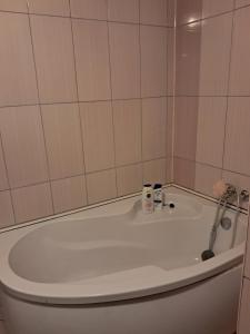 a bath tub with two bottles on top of it at Căsuța galbenă in Bucharest