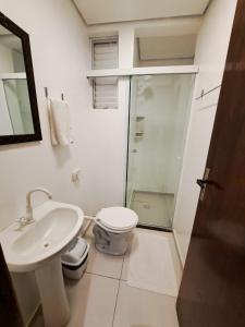 a bathroom with a toilet and a sink and a shower at Gravata Hotel frente mar in Navegantes +12 photos