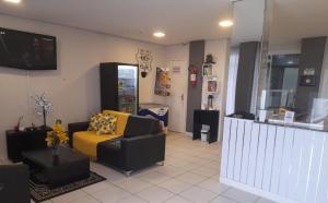 a living room with a couch and a tv at Gravata Hotel frente mar in Navegantes