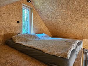 a bed in a room with a window at Domek wypoczynkowy in Kamionka