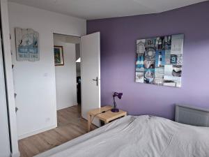a bedroom with a bed and a purple wall at St Marc proche plage, 2 chambres in Saint-Nazaire +18 photos