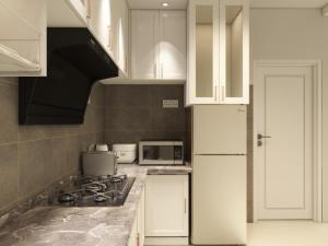 a kitchen with white cabinets and a stove top oven at Puteri Residence in Kuala Terengganu +10 photos