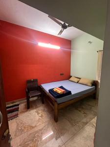 ein kleines Zimmer mit einem Bett und einem Stuhl in der Unterkunft Tranquil Heaven in Puducherry