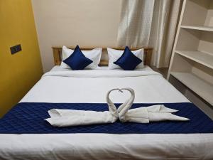 ein Bett mit zwei Handtüchern in Herzform in der Unterkunft Tranquil Heaven in Puducherry