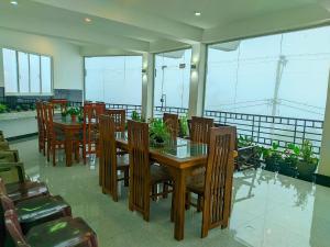 a dining room with wooden tables and chairs and windows at White House in Haputale