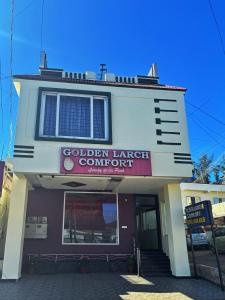 a building with a sign that reads golden lunchcourt company at Golden Larch Comfort in Ooty