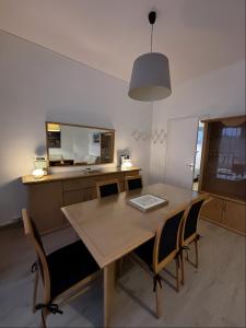 a kitchen with a wooden table and chairs at Le Cottage Malouin in Dunkerque