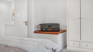 a suitcase sitting on a shelf in a bedroom at Double Bedroom Spacious Home near NEC JLR HS2 BHX Airport with Free Parking and wifi in Solihull