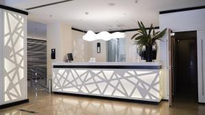 lobby z recepcją z doniczką w obiekcie Vértice Sevilla w Sewilli