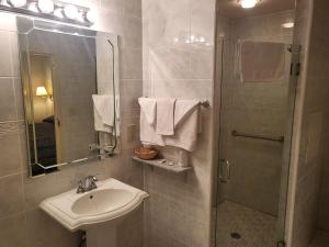 a bathroom with a sink and a shower with a mirror at Roosevelt Inn at Roosevelt Blvd, Philadelphia, PA in Philadelphia