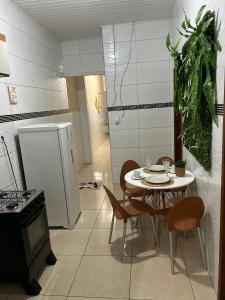 una cucina con tavolo, sedie e frigorifero di Residencial Barbosa ad Aracaju Altre 19 foto