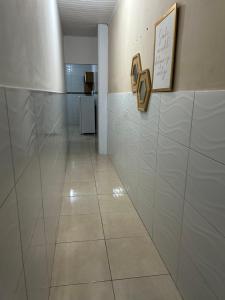 un corridoio con pareti piastrellate bianche e pavimento piastrellato di Residencial Barbosa ad Aracaju