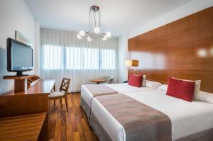 ein Hotelzimmer mit Bett und Flachbildfernseher in der Unterkunft Allegro Murcia Azarbe in Murcia