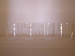 four empty glasses sitting on top of a table at 1日1組限定 2名利用 ESPLANADE VILLAGE HOTEL a 宿泊期間中 由比ガ浜レンタルオフィス利用無料 in Kamakura