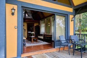 a screened in porch with two chairs and a table at Shamba Lodge Cabin X in Arusha