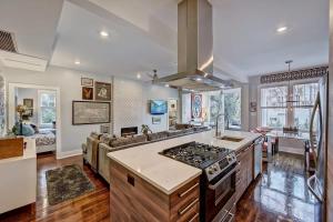 a kitchen with a stove top oven next to a living room at Modern 2BR Condo with Sunroom near Uptown in Charlotte