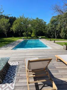 a chair sitting on a patio next to a swimming pool at La Rochelle Exceptional Property, Park, Pool, in La Rochelle