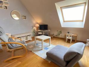 a living room with a couch and a table at La Clairière in Jullouville-les-Pins