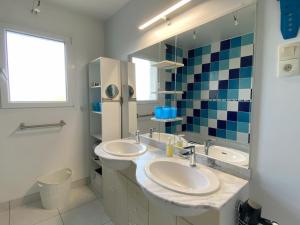 a bathroom with two sinks and a large mirror at La Clairière in Jullouville-les-Pins +38 photos