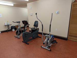 a gym with three exercise bikes in a room at Chalet Mont Sainte-Anne in Beaupré