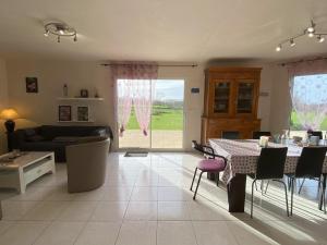 a living room with a table and a couch at La Clairière in Jullouville-les-Pins