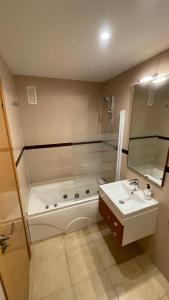 un bagno con vasca, lavandino e WC di Apartamento Magic World Neptuno a El Borseral