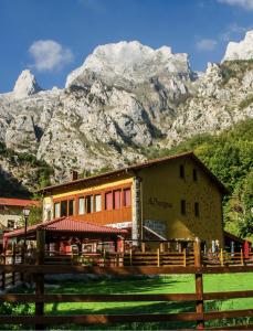 a building with a mountain in the background at Albergue de Caín "El Diablo de la peña" in Caín
