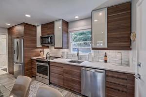 a kitchen with wooden cabinets and stainless steel appliances at Spacious Conveniently Located 1BR in Myers Park in Charlotte +30 photos