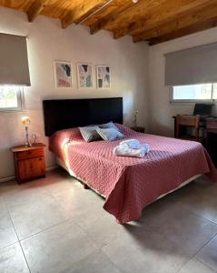 a bedroom with a bed with a red bedspread at LA CLARITA Chapadmalal in Chapadmalal