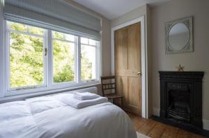 a bedroom with a bed and a fireplace and a mirror at Lilac Cottage by Keepers Cottages in Kingsdown