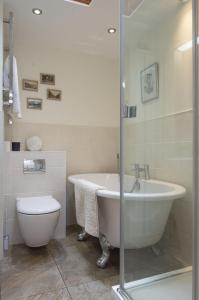 a bathroom with a bath tub and a toilet at Lilac Cottage by Keepers Cottages in Kingsdown +23 photos
