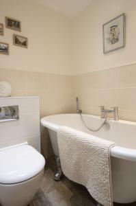 a bathroom with a tub and a toilet and a sink at Lilac Cottage by Keepers Cottages in Kingsdown
