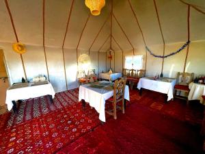メルズーガにあるMariam Desert Campのテント内のテーブルと椅子が備わる客室です。