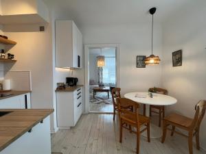 a kitchen and dining room with a table and chairs at Hercoga Jekaba Apartaments in Kuldīga