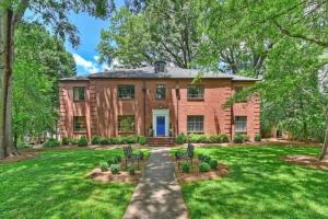 a brick house with chairs in a yard at Elegant 2BR with Covered Patio in Charlotte