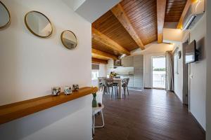 a kitchen and living room with wood ceilings at Shalamu Luxury Apartments in Rosolini