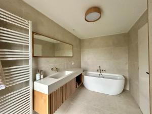 a bathroom with a white tub and a sink at Villa Stella-plage proche Le Touquet pour 8 personnes in Cucq +33 photos