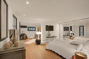 a white bedroom with a large bed and a mirror at Villa Bayugita in Port Grimaud +68 photos