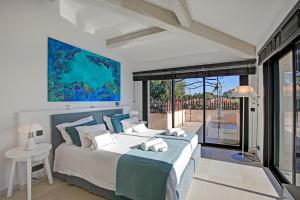 a bedroom with a bed and a large window at Villa Bayugita in Port Grimaud