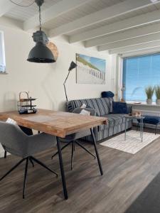 a living room with a wooden table and a couch at ZeeBedStay in Noordwijk aan Zee