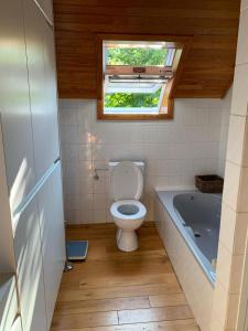 フーフェルラントにあるAppartement met terras 2 - 8 gasten Heuvelland Rodebergのバスルーム(トイレ、バスタブ付)、窓が備わります。