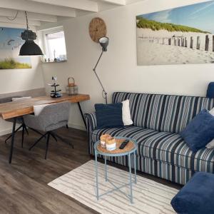 a living room with a couch and a desk at ZeeBedStay in Noordwijk aan Zee