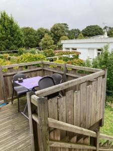 a wooden deck with a table and chairs on it at St Marc proche plage, 2 chambres in Saint-Nazaire