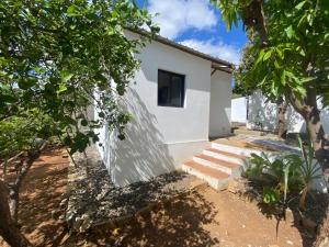 a white house with a window and some trees at Seromue in Diego Suarez