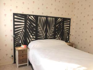 a bed with a black headboard in a bedroom at Appartement 2 pièces avec parking privé, proche plage et commerces, Saint-Gilles-Croix-de-Vie - FR-1-224-783 in Saint-Gilles-Croix-de-Vie