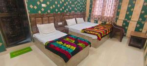 una camera con due letti in una stanza con di OYO 82076 Hotel Balaji Palace a Ayodhya