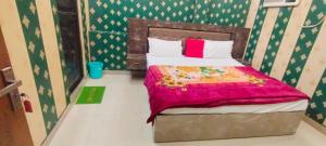 una piccola camera con un letto con una coperta rosa di OYO 82076 Hotel Balaji Palace a Ayodhya Altre 25 foto