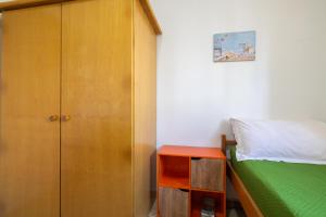 a bedroom with a bed and a wooden cabinet at Lucrezia - Relax, Piscina, Barbeque e Wi-Fi in Nardò