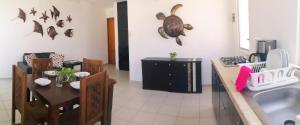 a kitchen with a sink and a table with chairs at Azul Mar Diving and Lodge in Puerto Morelos